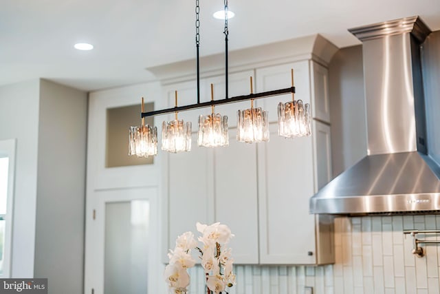 room details featuring a chandelier, recessed lighting, and wall chimney exhaust hood