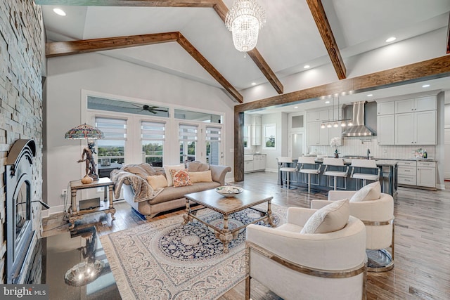 living room featuring recessed lighting, beamed ceiling, light wood-style floors, ceiling fan with notable chandelier, and high vaulted ceiling