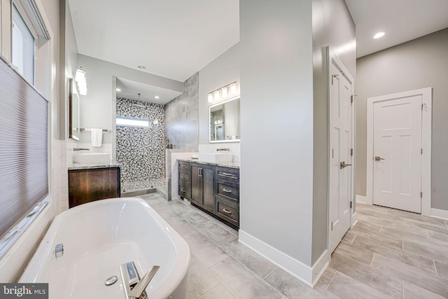 bathroom featuring a stall shower, recessed lighting, a soaking tub, and vanity