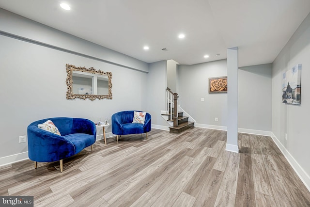 living area with baseboards, recessed lighting, wood finished floors, and stairs
