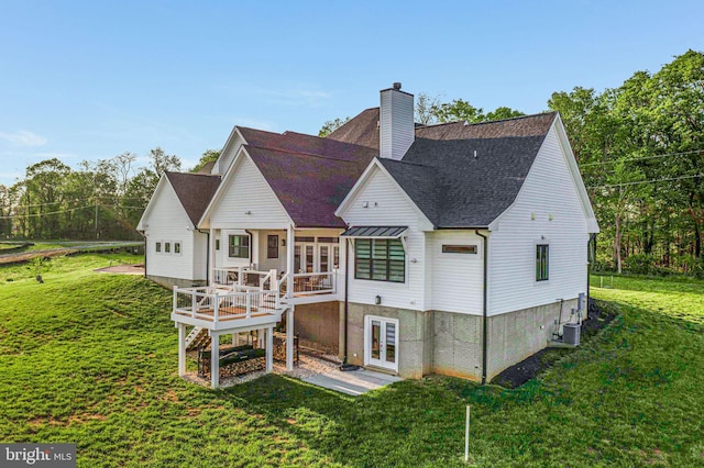 rear view of property featuring a deck, a chimney, roof with shingles, a yard, and french doors