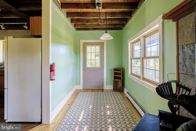 entryway with a baseboard heating unit, light wood-type flooring, and baseboards
