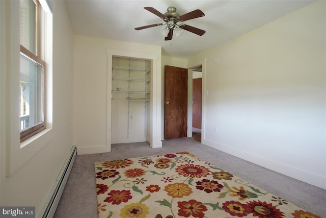 bedroom featuring light carpet, baseboard heating, baseboards, and a closet