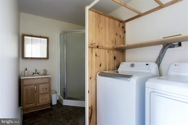 washroom with cabinet space, a sink, and independent washer and dryer