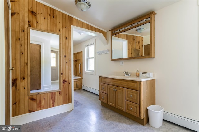 bathroom featuring baseboard heating, wood walls, and vanity
