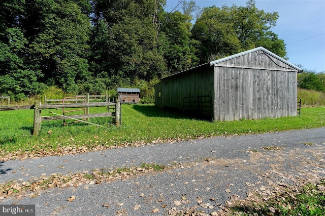 view of pole building with fence and a lawn
