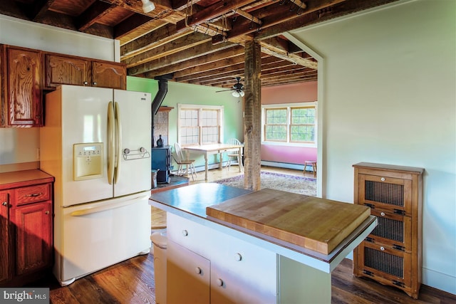 kitchen featuring baseboard heating, white refrigerator with ice dispenser, ceiling fan, dark wood-type flooring, and a kitchen island