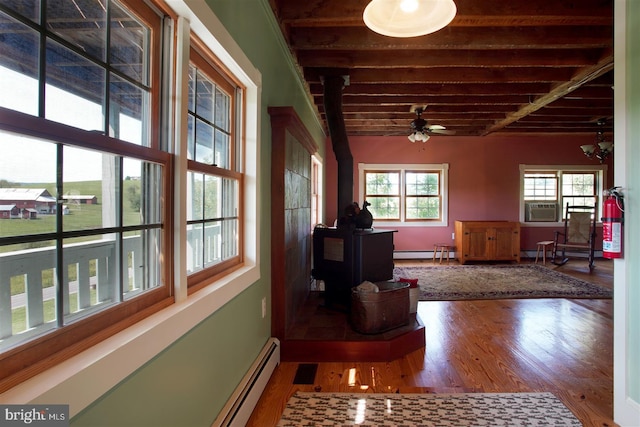 hall with a baseboard heating unit, baseboards, cooling unit, and wood finished floors
