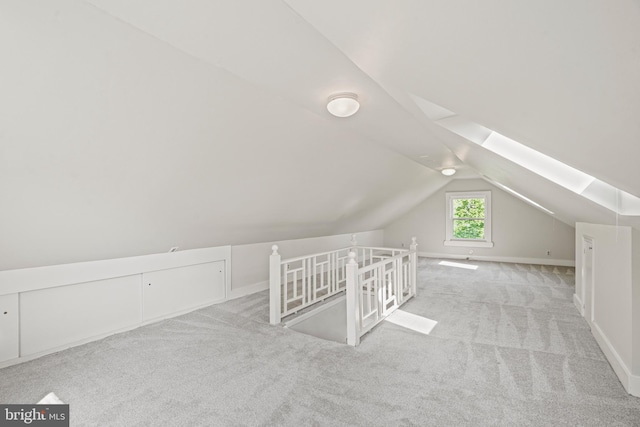 additional living space featuring carpet flooring, baseboards, and vaulted ceiling