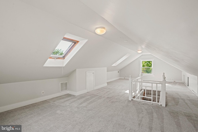 bonus room featuring carpet flooring, baseboards, visible vents, and lofted ceiling with skylight