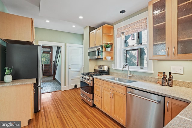 kitchen with a sink, light brown cabinets, stainless steel appliances, decorative light fixtures, and recessed lighting