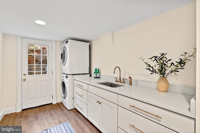 119 Seaton Pl NW, Washington, DC 20001 - washroom with a sink, cabinet space, stacked washer / drying machine, light wood finished floors, and baseboards