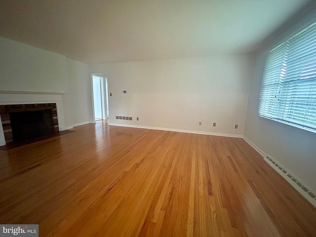 113 Edgeroad Ln, Wilmington, DE 19803 - unfurnished living room with light wood finished floors, a baseboard heating unit, a brick fireplace, and baseboards
