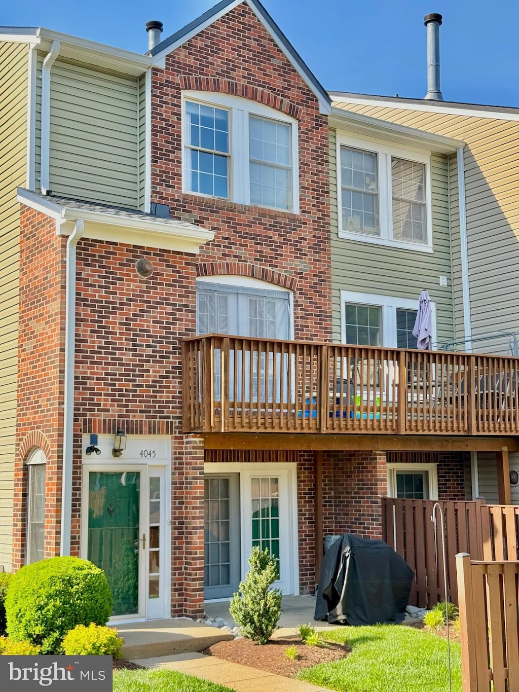 rear view of property with brick siding and fence