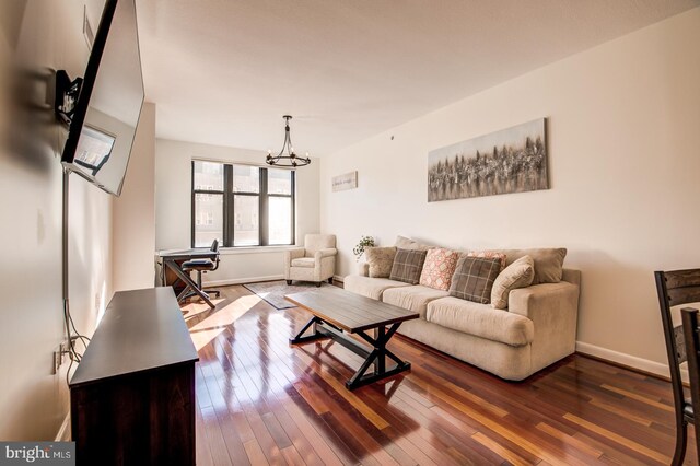 living area featuring hardwood / wood-style flooring, baseboards, and a chandelier
