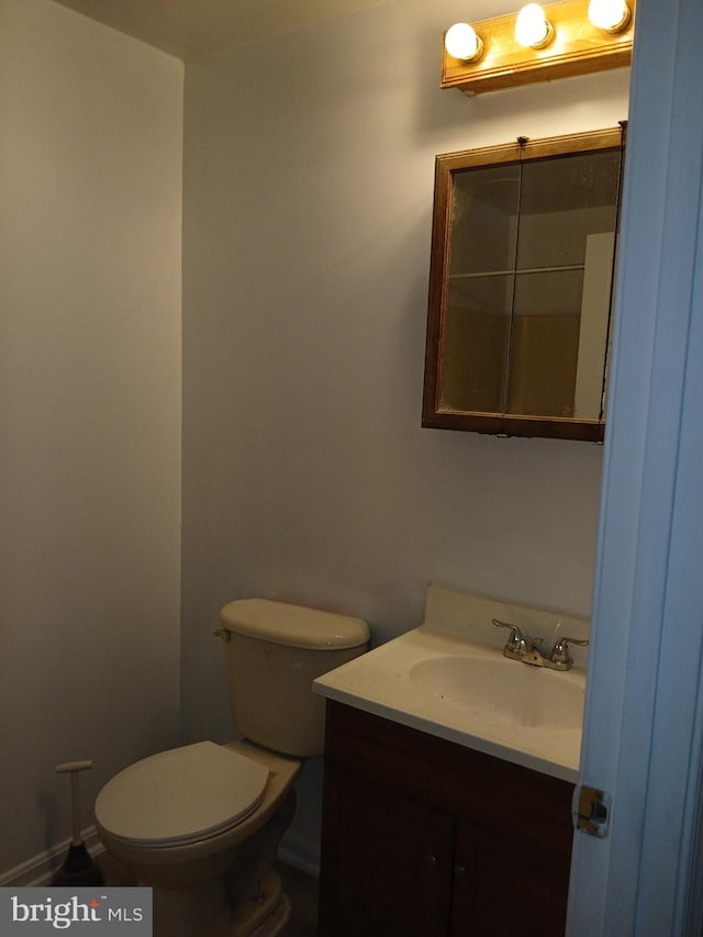 half bathroom with vanity and toilet