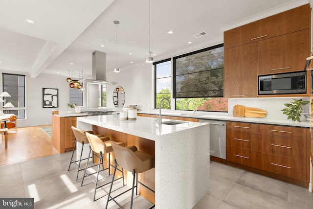 kitchen with brown cabinetry, visible vents, modern cabinets, a sink, and appliances with stainless steel finishes