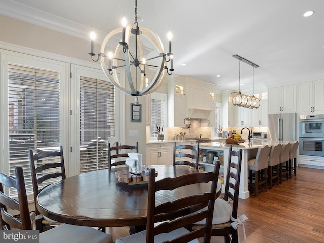 dining space with crown molding, recessed lighting, a notable chandelier, and dark wood-style floors