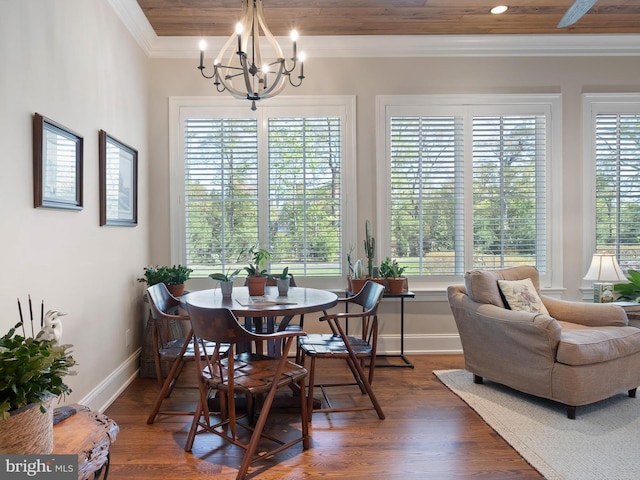 dining area featuring an inviting chandelier, baseboards, crown molding, and dark wood finished floors