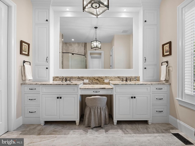 bathroom featuring visible vents, double vanity, a stall shower, and a chandelier