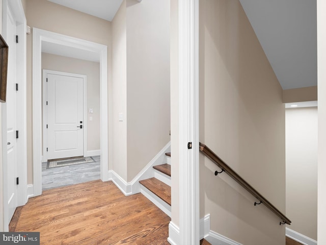 stairway with baseboards and wood finished floors