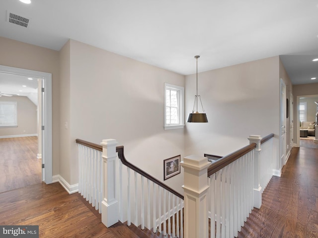 staircase with plenty of natural light, wood finished floors, and visible vents