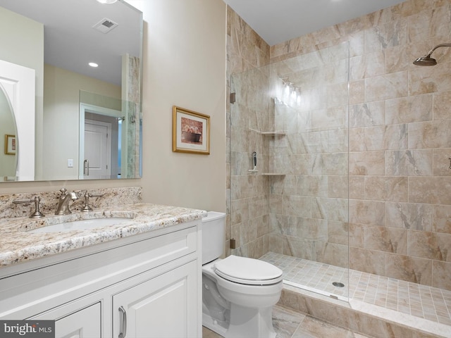 full bathroom featuring vanity, toilet, tiled shower, and visible vents