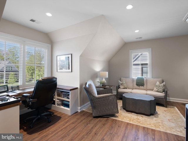 office space with plenty of natural light, visible vents, wood finished floors, and lofted ceiling