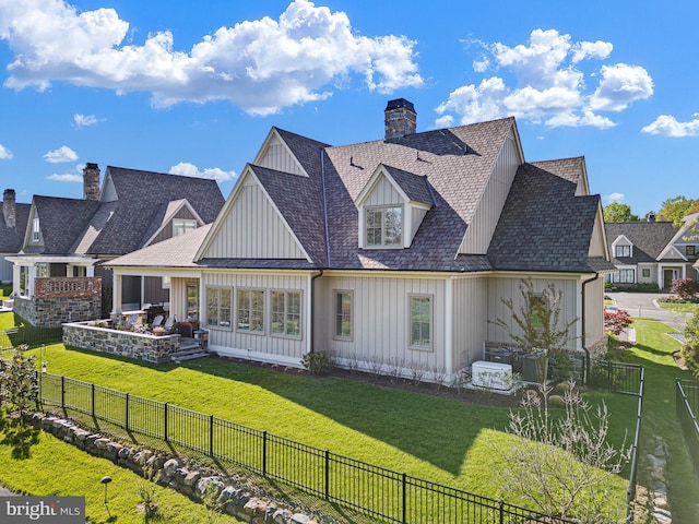 back of house featuring a fenced backyard, board and batten siding, and a yard