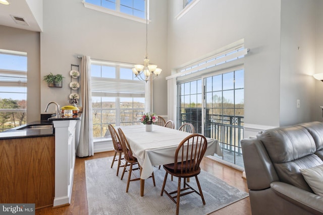 820 Belmont Bay Dr Unit 405, Woodbridge, VA 22191 - dining area featuring a towering ceiling, wood finished floors, visible vents, and an inviting chandelier
