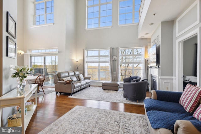 820 Belmont Bay Dr Unit 405, Woodbridge, VA 22191 - living area with a high ceiling, a wainscoted wall, wood finished floors, and a fireplace