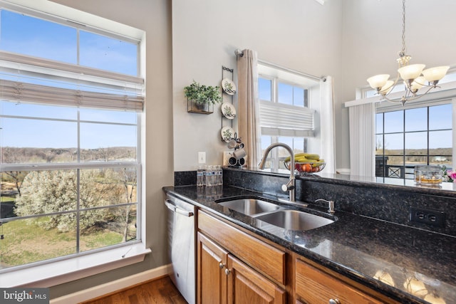 820 Belmont Bay Dr Unit 405, Woodbridge, VA 22191 - kitchen featuring stainless steel dishwasher, a sink, dark stone counters, a notable chandelier, and brown cabinets