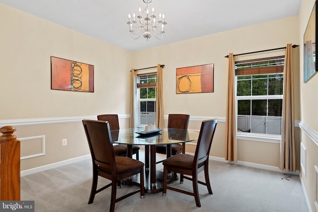 dining area featuring light colored carpet, baseboards, and a notable chandelier