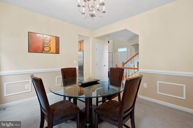 dining space featuring an inviting chandelier, baseboards, light carpet, and stairs