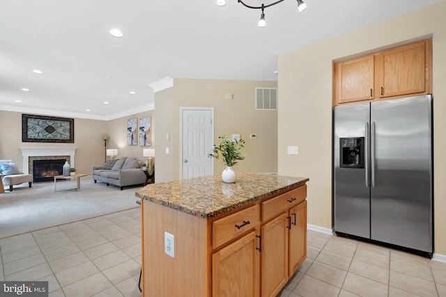 kitchen with a center island, stainless steel refrigerator with ice dispenser, light tile patterned flooring, and visible vents