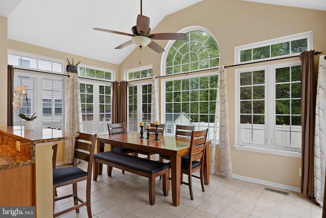 dining room featuring a ceiling fan, visible vents, vaulted ceiling, light tile patterned floors, and baseboards
