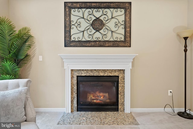 room details with a high end fireplace, carpet floors, and baseboards