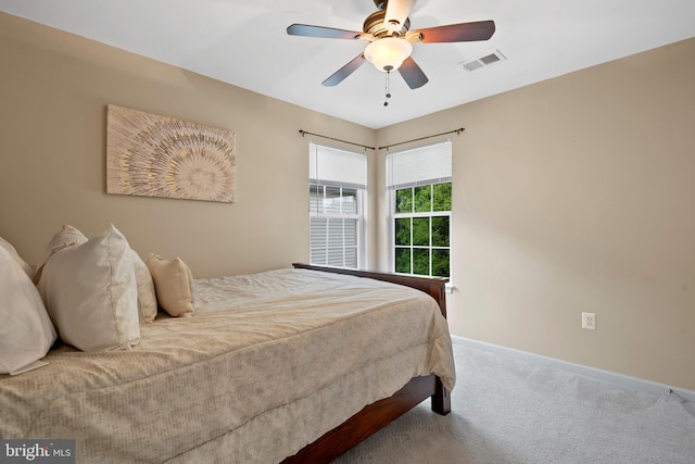 carpeted bedroom featuring visible vents, baseboards, and ceiling fan