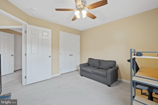 sitting room with ceiling fan, baseboards, and carpet