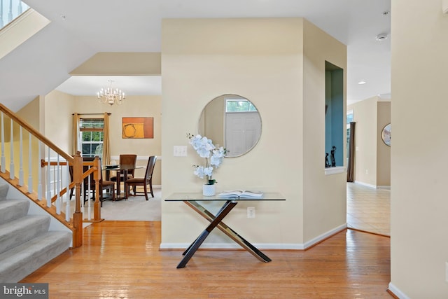 foyer entrance featuring an inviting chandelier, light wood finished floors, recessed lighting, baseboards, and stairway