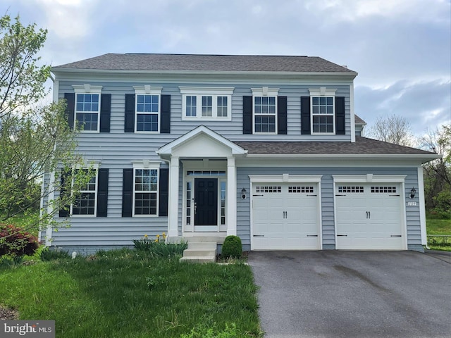 view of front of property with roof with shingles, aphalt driveway, and an attached garage