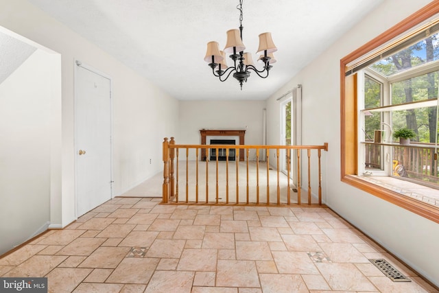 8005 Hillrise Ct, Elkridge, MD 21075 - unfurnished room featuring stone tile flooring, plenty of natural light, a chandelier, and baseboards