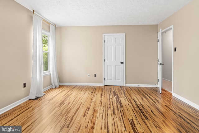 8005 Hillrise Ct, Elkridge, MD 21075 - unfurnished bedroom featuring wood finished floors, baseboards, and a textured ceiling