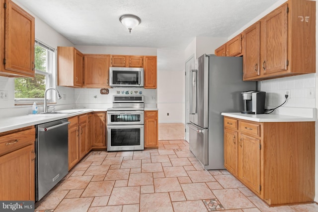 8005 Hillrise Ct, Elkridge, MD 21075 - kitchen with appliances with stainless steel finishes, a sink, light stone finish floors, decorative backsplash, and light countertops