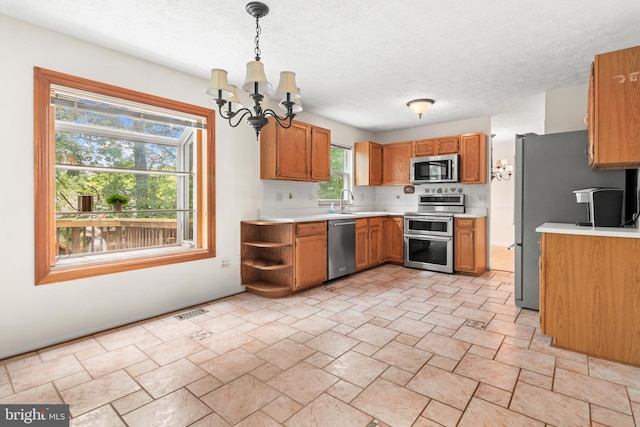 8005 Hillrise Ct, Elkridge, MD 21075 - kitchen featuring stainless steel appliances, a chandelier, light countertops, brown cabinetry, and a textured ceiling