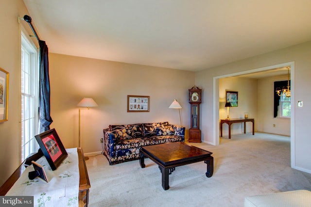 living area with a notable chandelier, carpet, and baseboards