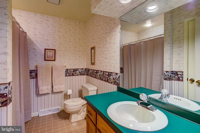 full bathroom with tile patterned floors, toilet, vanity, and wallpapered walls