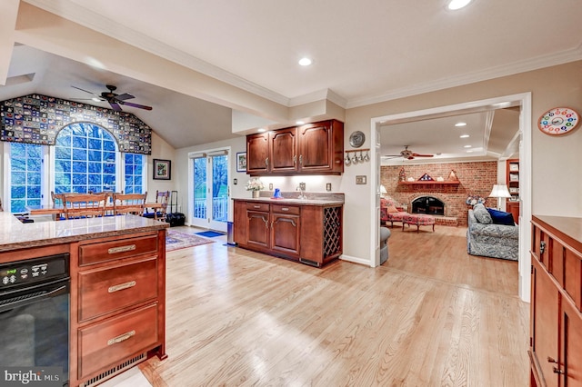 14712 Manor Rd, Phoenix, MD 21131 - kitchen with a ceiling fan, light wood-style floors, a fireplace, lofted ceiling, and light countertops