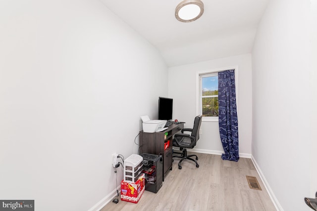 office space featuring baseboards, visible vents, wood finished floors, and lofted ceiling