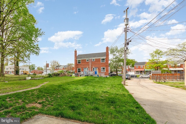 view of front facade with fence, a chimney, a residential view, and a front lawn